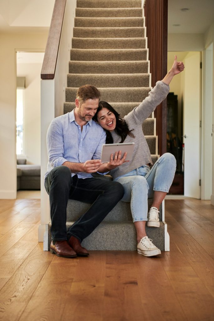 woman-celebrating-besides-man-looking-at-tablet-p9kddb8apme